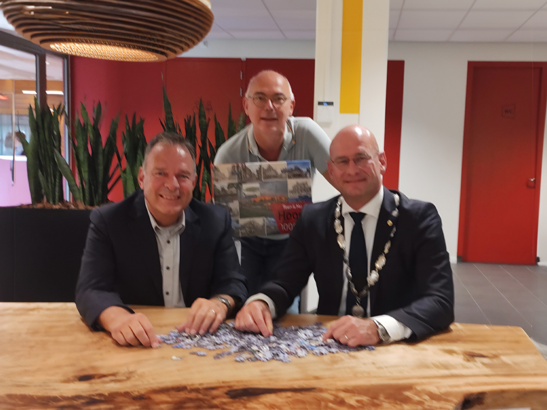 Burgemeester Jan Nieuwenburg ontvangt de eerste exemplaar van de nieuwe Hoorn puzzel