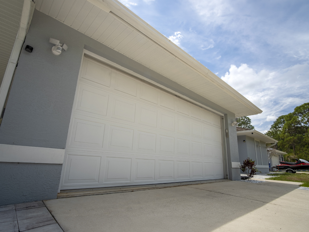 brede garage met dubbele deur en betonnen oprit